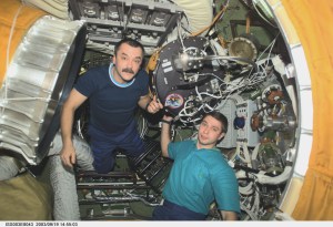 Cosmonaut Mikhail Tyurin (left), Expedition Three flight engineer, and Soyuz Taxi crewmember, Flight Engineer Konstantin Kozeev, work in the Zvezda Service Module’s transfer compartment on the International Space Station (ISS). Tyurin and Kozeev represent Rosaviakosmos.