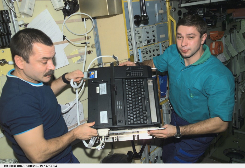 Cosmonaut Mikhail Tyurin (left), Expedition Three flight engineer, and Soyuz Taxi crewmember, Flight Engineer Konstantin Kozeev work in the Zvezda Service Module on the International Space Station. Tyurin and Kozeev represent Rosaviakosmos. This image was taken with a digital still camera.