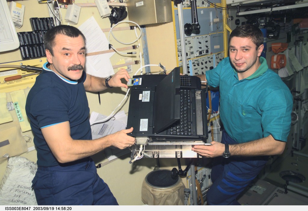 Cosmonaut Mikhail Tyurin (left), Expedition Three flight engineer, and Soyuz Taxi crewmember, Flight Engineer Konstantin Kozeev work in the Zvezda Service Module on the International Space Station. Tyurin and Kozeev represent Rosaviakosmos. This image was taken with a digital still camera.