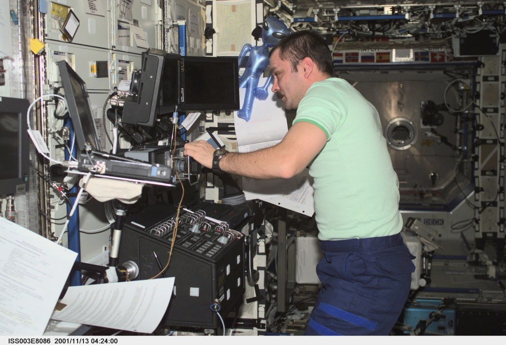 Cosmonaut Mikhail Tyurin, Expedition Three flight engineer representing Rosaviakosmos, works the controls of the Canadarm2, or Space Station Remote Manipulator System (SSRMS) in the Destiny laboratory on the International Space Station (ISS). This image was taken with a digital still camera.