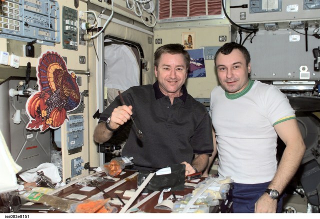 Astronaut Frank L. Culbertson (left), Expedition 3 mission commander, and cosmonaut Vladimir N. Dezhurov, flight engineer representing Rosaviakosmos, eat a Thanksgiving meal in the Zvezda Service Module on the International Space Station (ISS).