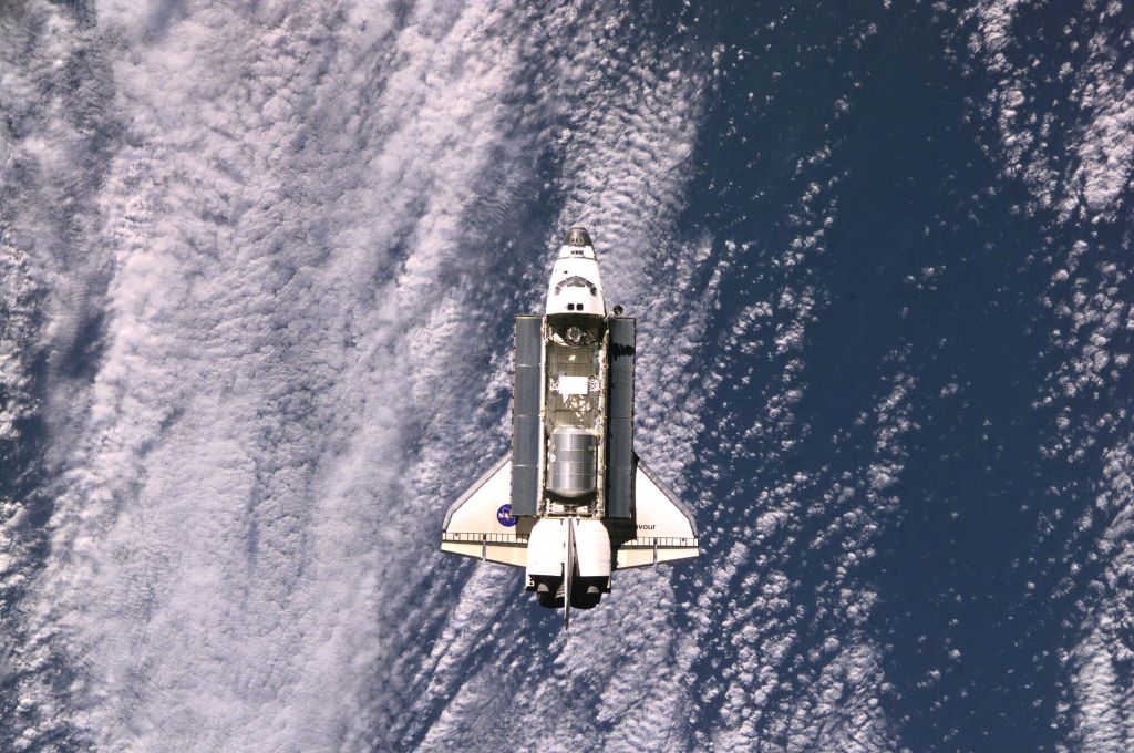 Backdropped against a large cloud mass on Earth, the Space Shuttle Endeavour, controlled by the flight crew of STS-108, approaches the International Space Station (ISS). Among other activities the Endeavour's mission will include the change out of the station crews. The image was recorded with a digital still camera.