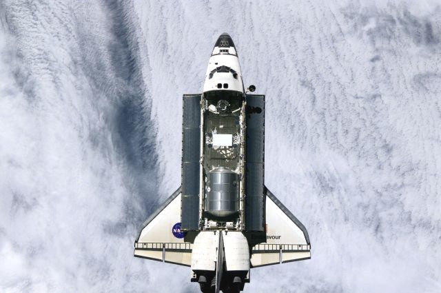 ISS003-E-8265 (7 December 2001) --- The Space Shuttle Endeavour is backdropped against a large cloud mass on Earth. Controlled by the flight crew of STS-108, the shuttle was approaching the International Space Station (ISS), from which this digital image was recorded. The logistics module Among other activities the Endeavour's mission will include the change out of the station crews.