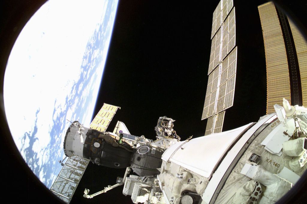 One of the Expedition Three crew members aimed a digital still camera through a window on the Russian segment of the International Space Station (ISS) to record this image of rendezvous operations with the Space Shuttle Endeavour. With six astronauts and a cosmonaut aboard, Endeavour was very near the point of docking at this point. Viewing of the shuttle in this scene is almost obstructed by the Soyuz vehicle docked above it.