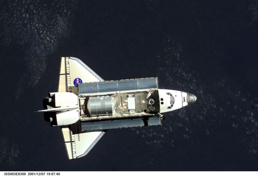 The Space Shuttle Endeavour, controlled by the flight crew of STS-108, is surrounded by darkness as it approaches the International Space Station (ISS). The Raffaello logistics module that is being brought up to the orbiting outpost is clearly visible in Endeavour's cargo bay. Among other activities the Endeavour's mission will include the change out of the station crews. The image was recorded with a digital still camera.