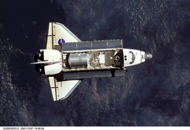 The Space Shuttle Endeavour, controlled by the flight crew of STS-108, is backdropped over a dark mass of clouds as it approaches the International Space Station (ISS). The Raffaello logistics module that is being brought up to the orbiting outpost is clearly visible in Endeavour's cargo bay. Among other activities the Endeavour's mission will include the change out of the station crews. The image was recorded with a digital still camera.