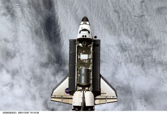 The Space Shuttle Endeavour, controlled by the flight crew of STS-108, is backdropped against a mass of clouds as it approaches the International Space Station (ISS). The Raffaello logistics module that is being brought up to the orbiting outpost is clearly visible in Endeavour's cargo bay. Among other activities the Endeavour's mission will include the change out of the station crews. The image was recorded with a digital still camera.