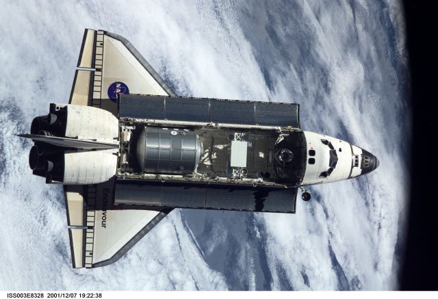 The Space Shuttle Endeavour, controlled by the flight crew of STS-108, is backdropped over a large area of cloud cover on Earth as it nears its rendezvous with the International Space Station (ISS). The Raffaello logistics module that is being brought up to the orbiting outpost is clearly visible in Endeavour's cargo bay. Among other activities the Endeavour's mission will include the change out of the station crews. The image was recorded with a digital still camera.
