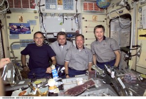Astronaut Carl E. Walz (left), Expedition Four flight engineer; cosmonaut Yuri I. Onufrienko, Expedition Four mission commander; along with astronauts Dominic L. Gorie, STS-108 mission commander, and Frank L. Culbertson, Jr., Expedition Three mission commander, pose for a group photo in the Zvezda Service Module on the International Space Station (ISS). Various food items are visible in the foreground. The image was taken with a digital still camera.