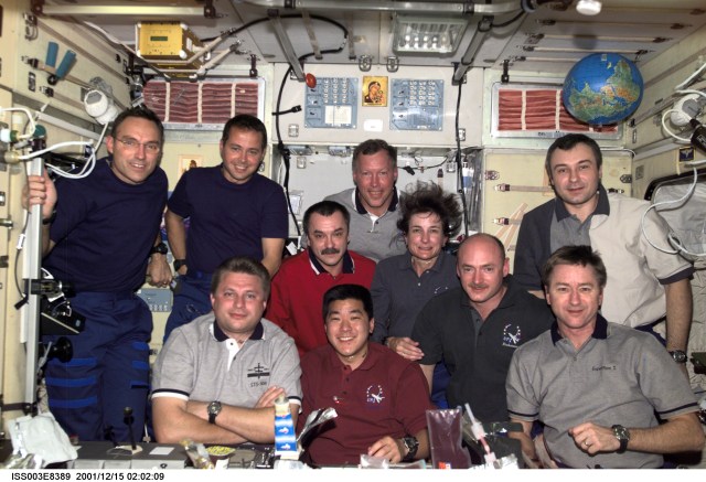 The Expedition Three, STS-108, and Expedition Four crews assemble for a group photo in the Zvezda Service Module on the International Space Station (ISS). From the left, front row, are cosmonaut Yuri I. Onufrienko, Expedition Four mission commander; astronaut Daniel M. Tani, STS-108 mission specialist; astronaut Mark E. Kelly, STS-108 pilot; and astronaut Frank L. Culbertson, Jr., Expedition Three mission commander. From the left, back row, are astronauts Carl E. Walz and Daniel W. Bursch, both Expedition Four flight engineers; cosmonaut Mikhail Tyurin, Expedition Three flight engineer; astronaut Dominic L. Gorie, STS-108 mission commander; astronaut Linda M. Godwin, STS-108 mission specialist; and cosmonaut Vladimir N. Dezhurov, Expedition Three flight engineer. The image was taken with a digital still camera.