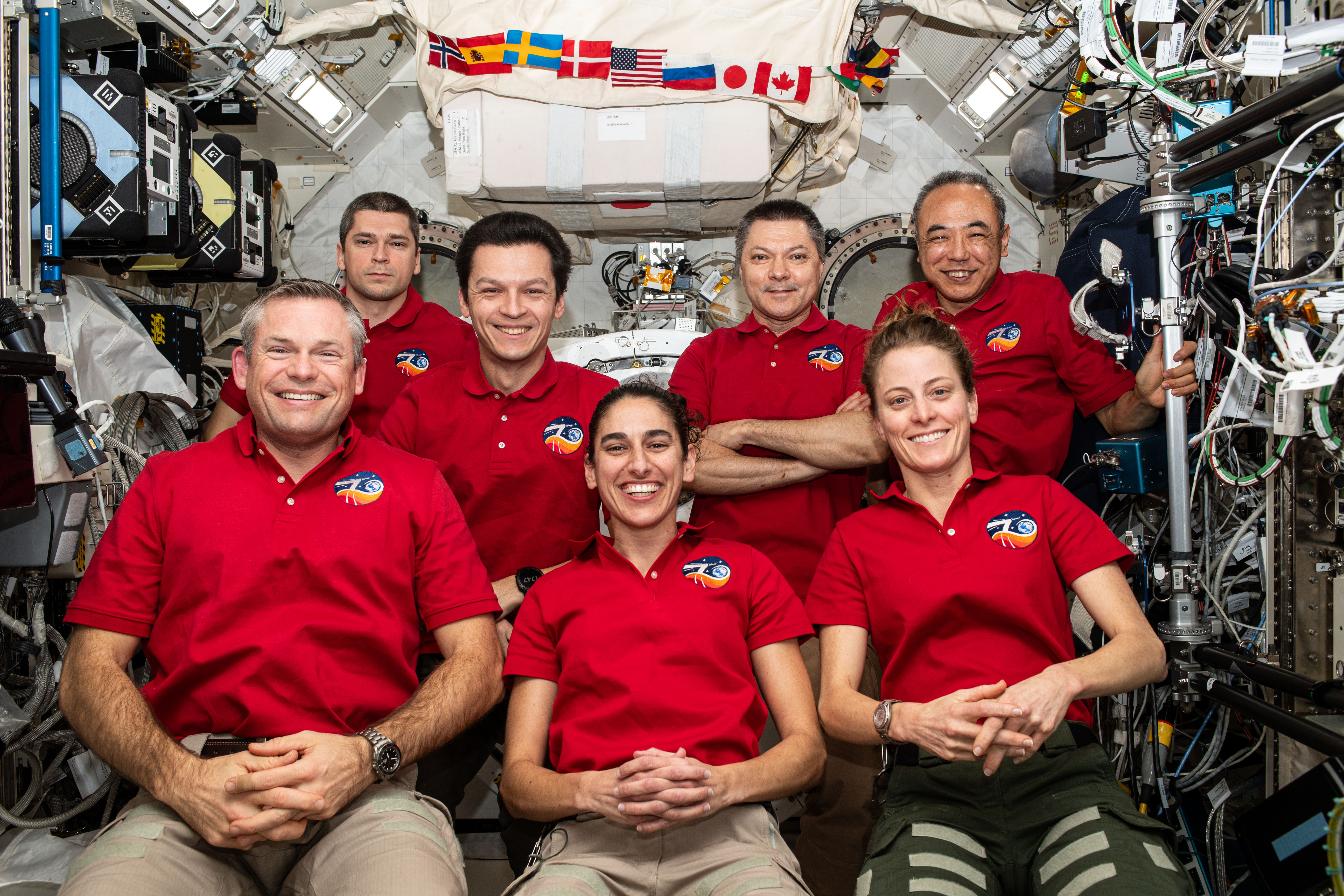 The seven-member Expedition 70 crew poses for a portrait inside the International Space Station's Kibo laboratory module. In the front row (from left) are, Commander Andreas Mogensen from ESA (European Space Agency) and NASA Flight Engineers Jasmin Moghbeli and Loral O'Hara. In the back are, Roscosmos Flight Engineers Nikolai Chub, Konstantin Borisov, and Oleg Kononenko; and JAXA (Japan Aerospace Exploration Agency) Flight Engineer Satoshi Furukawa.