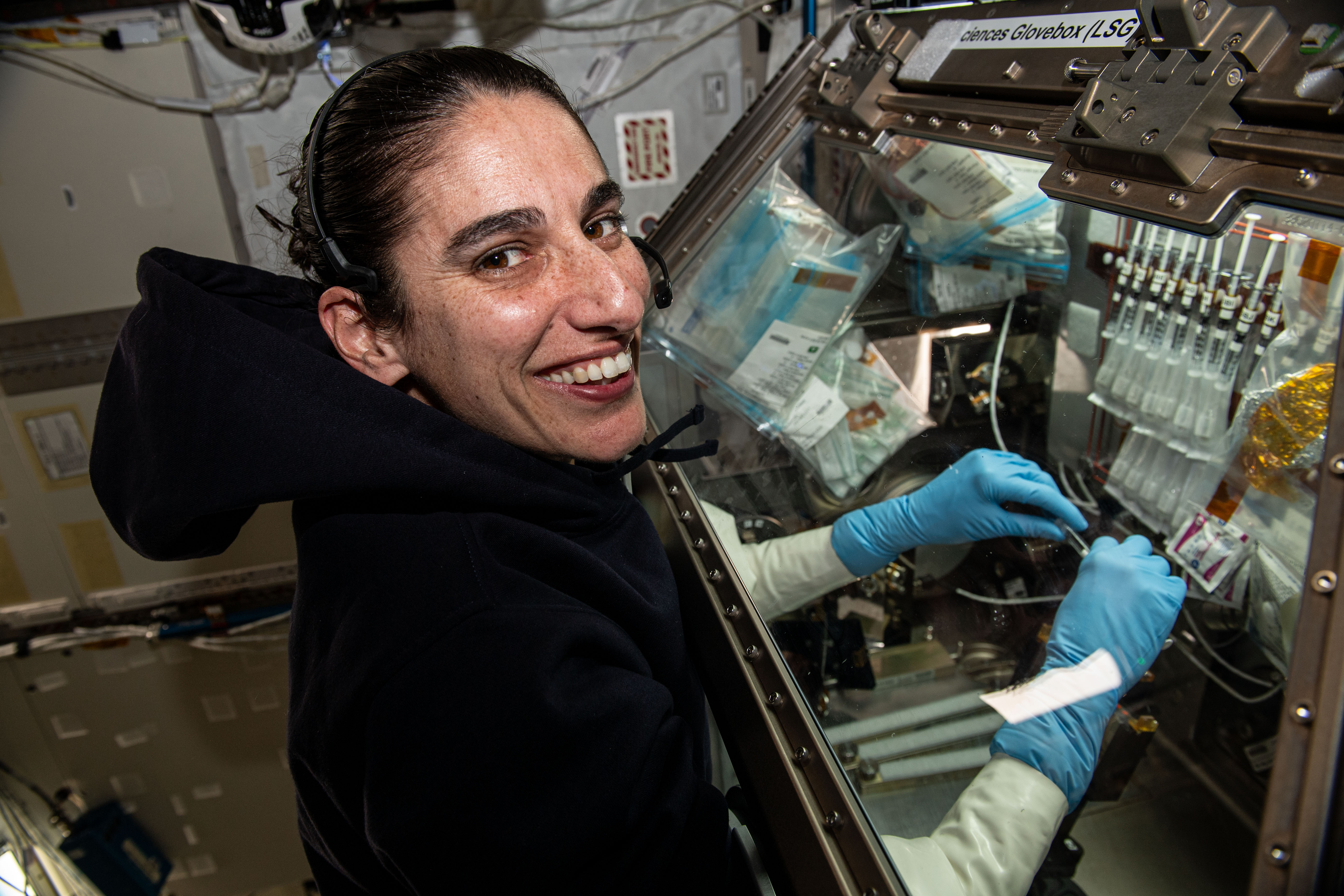 NASA astronaut and Expedition 70 Flight Engineer Jasmin Moghbeli processes bacteria samples inside the Kibo laboratory module’s Life Science Glovebox to learn how to control microbial growth in microgravity. The Bacteria Adhesion and Corrosion experiment is exploring how to identify and disinfect microbes that can contaminate spacecraft systems and affect crew health.