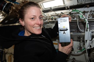 NASA astronaut and Expedition 70 Flught Engineer Loral O'Hara shows off research hardware supporting the UMAMI, or Understanding of Microgravity on Animal-Microbe Interaction, space biology experiment. O'Hara is holdng the Avanced Space Experiment Processor (ADSEP) Fluid Processing Cassette (FPC) that supports the observation of the effects of spaceflight on the molecular and chemical interactions between beneficial microbes and their animal hosts.