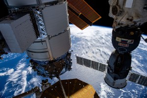 Northrop Grumman's Cygnus space freighter (at left) and the Roscosmos Soyuz MS-24 crew ship (right) are pictured attached to the International Space Station while orbiting 263 miles above the Indian Ocean. At lower left, is the Canadarm2 robotic arm preparing to grapple Cygnus ahead of its removal from the Unity module and departure from the orbital outpost.