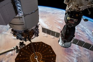 Northrop Grumman's Cygnus space freighter (at left) and the Roscosmos Soyuz MS-24 crew ship (right) are pictured attached to the International Space Station while orbiting 259 miles above the African nation of Mali. At lower left, is the Canadarm2 robotic arm preparing to grapple Cygnus ahead of its removal from the Unity module and departure from the orbital outpost.