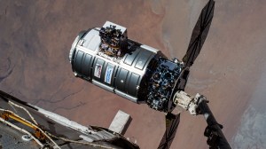 Northrop Grumman's Cygnus space freighter is pictured in the grip of the Canadarm2 robotic arm moments before its release. The orbital complex was soaring 258 miles above the African nation of Chad at the time of this photograph.