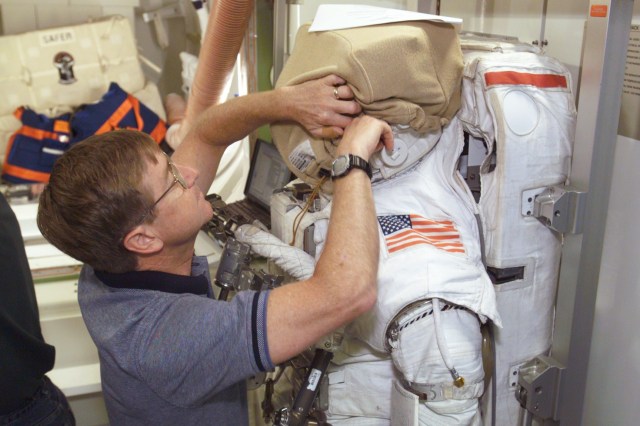 Astronaut Frank L. Culbertson, Jr., Expedition Three mission commander, works with a training version of the Extravehicular Mobility Unit (EMU) in the International Space Station (ISS) Airlock trainer/mockup in the Systems Integration Facility at Johnson Space Center (JSC).