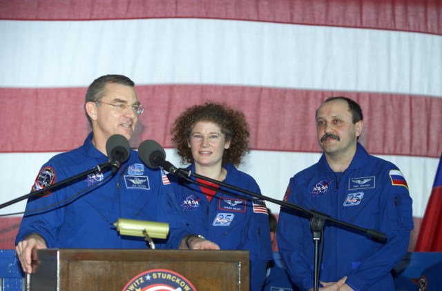 The Expedition Two crew consisting of James S. Voss (left) and Susan J. Helms, flight engineers, and cosmonaut Yury V. Usachev, mission commander, field questions at the podium in Hangar 990 at Ellington Field during the STS-105 and Expedition Two crew return ceremonies. Voss, Helms and Usachev spent five months aboard the International Space Station (ISS).