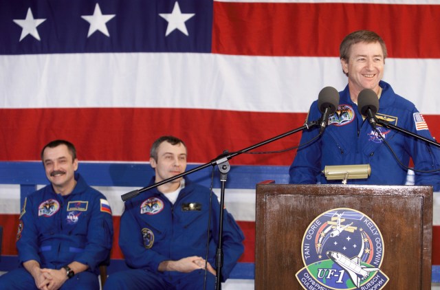 Astronaut Frank L. Culbertson, Jr., Expedition Three mission commander, speaks from the podium in Hangar 990 at Ellington Field during the STS-108 and Expedition Three crew return ceremonies. Seated (from left) are cosmonauts Mikhail Tyurin and Vladimir N. Dezhurov, both Expedition Three flight engineers representing Rosaviakosmos. The STS-108 crew delivered the Expedition Four crew and supplies to the International Space Station (ISS) and brought the Expedition Three crew back to Earth.
