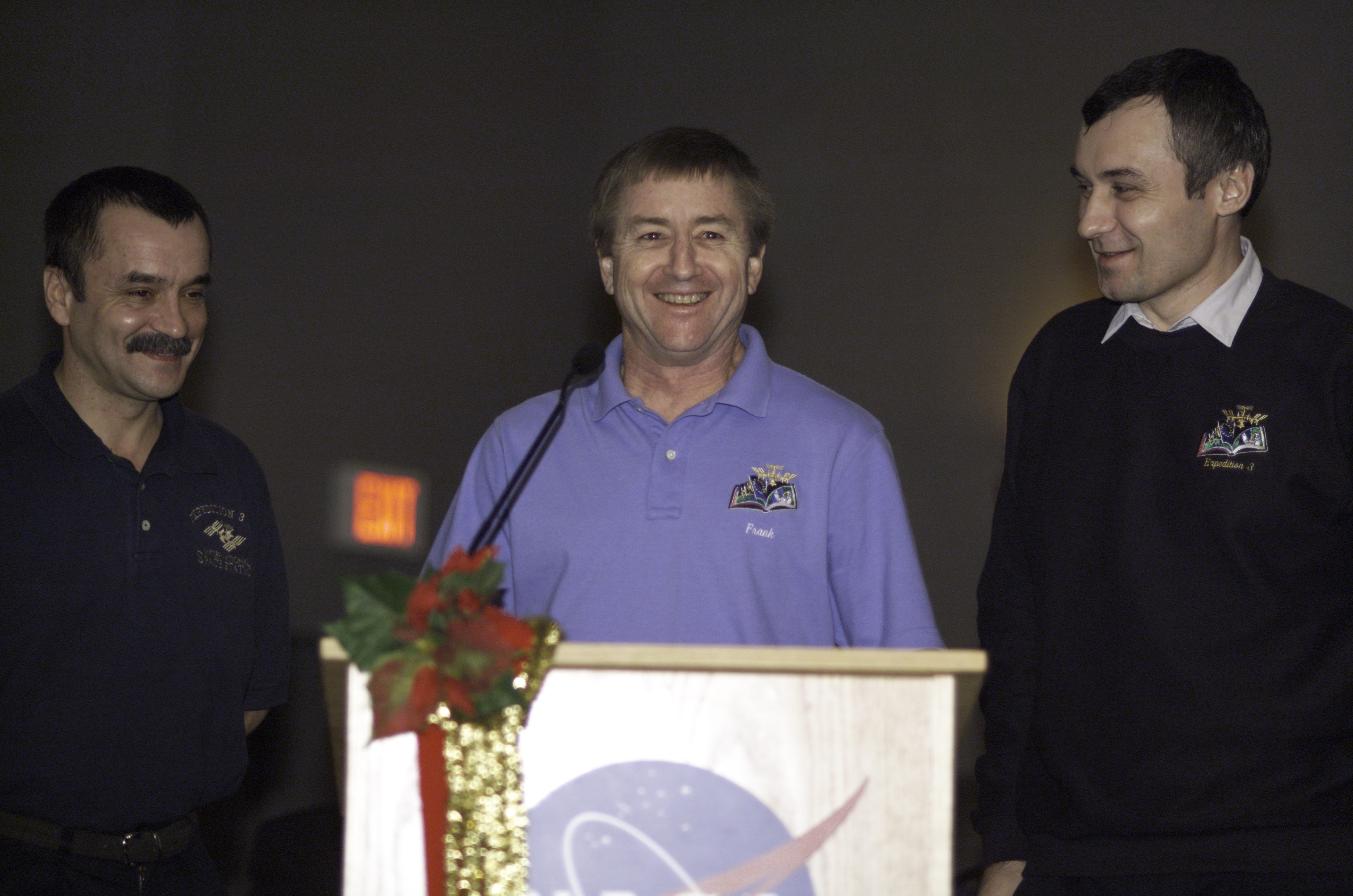 Astronaut Frank L. Culbertson, Jr., Expedition Three mission commander, flanked by cosmonauts Mikhail Tyurin (left) and Vladimir N. Dezhurov, both flight engineers, speak from the lectern in the ballroom of the Gilruth Center at Johnson Space Center (JSC) during the Expedition Three Welcome Home ceremony. Tyurin and Dezhurov represent Rosaviakosmos.