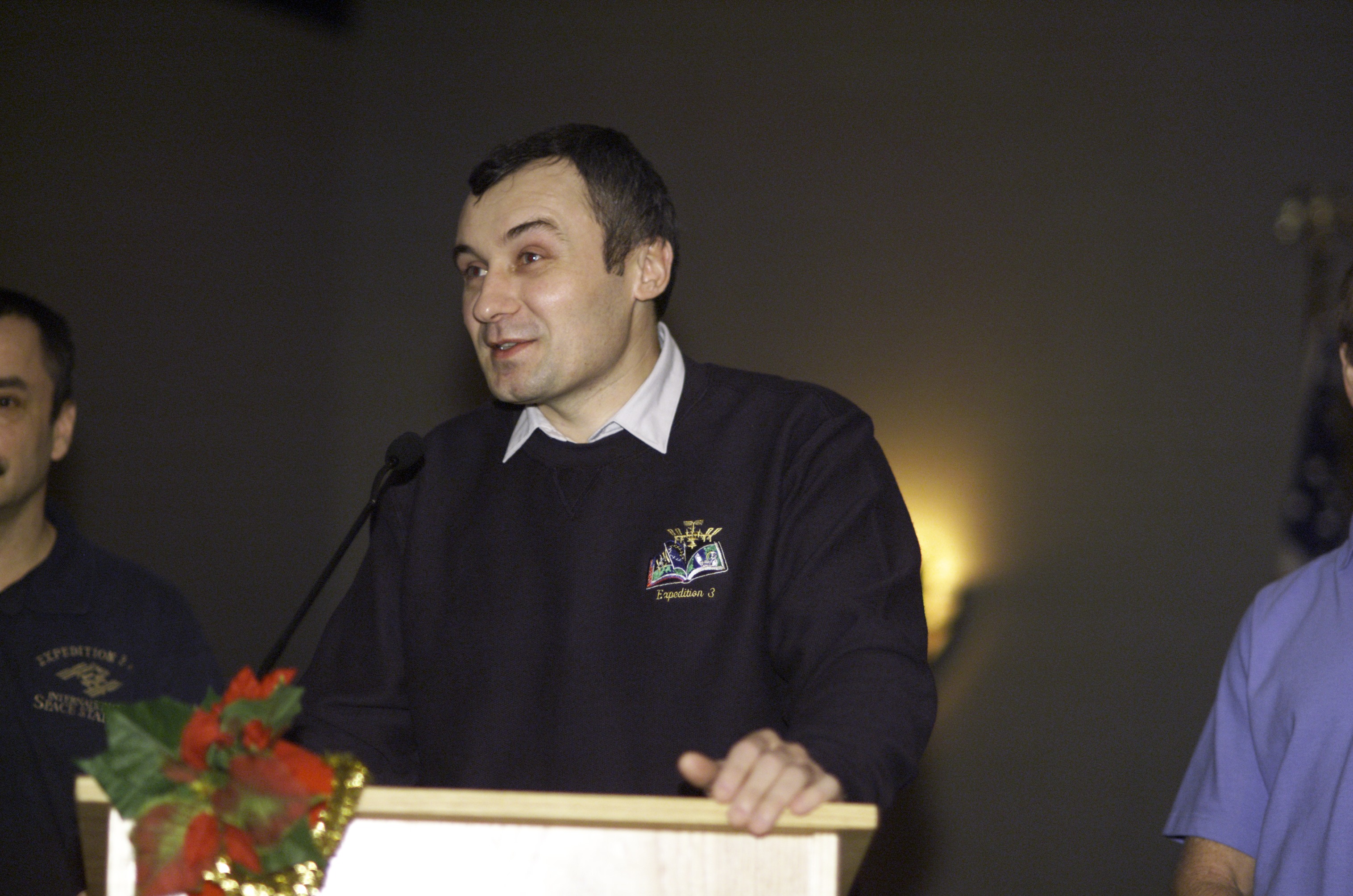 Cosmonaut Vladimir N. Dezhurov, Expedition Three flight engineer representing Rosaviakosmos, speaks from the lectern in the ballroom of the Gilruth Center at Johnson Space Center (JSC) during the Expedition Three Welcome Home ceremony.