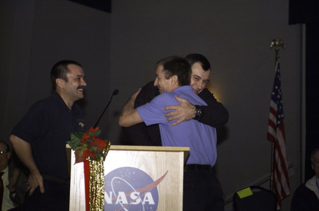 Astronaut Frank L. Culbertson, Jr. (right), Expedition Three mission commander, and cosmonaut Vladimir N. Dezhurov, flight engineer, embrace in the ballroom of the Gilruth Center at Johnson Space Center (JSC) during the Expedition Three Welcome Home ceremony. Cosmonaut Mikhail Tyurin, flight engineer, looks on. Dezhurov and Tyurin represent Rosaviakosmos.