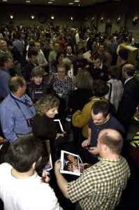 Cosmonaut Mikhail Tyurin, Expedition Three flight engineer representing Rosaviakosmos, looks at the crew portrait held by a guest among the crowd in the ballroom of the Gilruth Center at Johnson Space Center (JSC) during the Expedition Three Welcome Home ceremony.