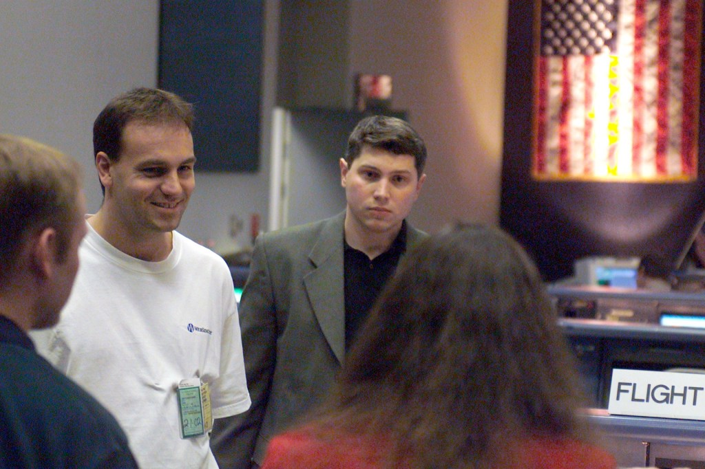 Soyuz 4 Flight Participant Mark Shuttleworth (white shirt), a South African businessman flying to the International Space Station (ISS) under a private commercial agreement with the Russian Aviation and Space Agency (Rosaviakosmos), listens to briefing in the Johnson Space Center's Mission Control Center (MCC). The Soyuz 4 prime and backup crews have toured several other JSC facilities this week, with yet others scheduled. The prime crew members will launch in late April from the Baikonur Cosmodrome, Kazakhstan, to deliver a fresh Soyuz spacecraft to the station for use as a lifeboat. After spending about a week aboard the outpost, they will return to Earth aboard the Soyuz spacecraft now attached to the station.