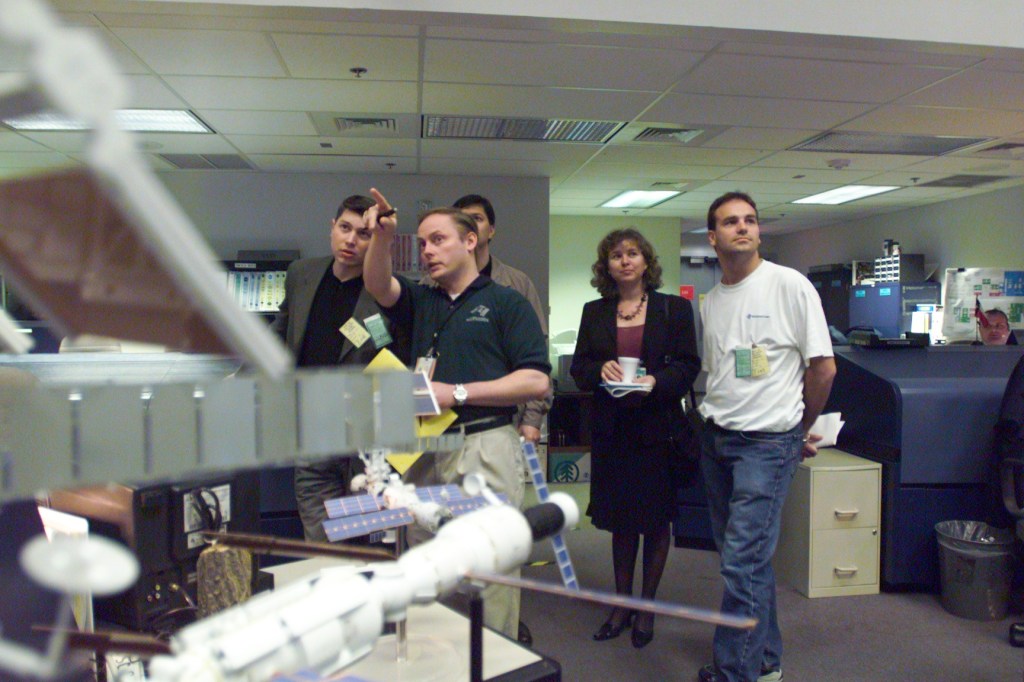 Astronaut Edward M. (Mike) Fincke (pointing) plays host for some Soyuz 4 taxi crew members who visited the Johnson Space Center's Mission Control Center on January 28. Soyuz 4 Flight Participant Mark Shuttleworth, a South African businessman flying to the International Space Station (ISS) under a private commercial agreement with the Russian Aviation and Space Agency (Rosaviakosmos), is at right. Others pictured include interpreter Irina Yashkova and Russian training management representative Dennis Yadrentsev (left). The Soyuz 4 prime and backup crews have toured several other JSC facilities this week, with yet others scheduled. The prime crew members will launch in late April from the Baikonur Cosmodrome, Kazakhstan, to deliver a fresh Soyuz spacecraft to the station for use as a lifeboat. After spending about a week aboard the outpost, they will return to Earth aboard the Soyuz spacecraft now attached to the station.