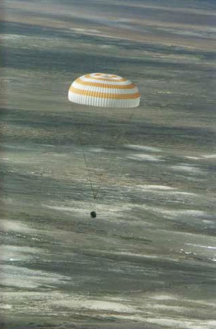 Soyuz TM-33 spacecraft, slowed greatly by a parachute, nears landing not far from the town of Arkalyk, Kazakhstan, to put the final touches on a successful Soyuz 4 ISS Taxi mission. Landing occurred at 7:52 a.m. Moscow time. Onboard were Yuri Gidzenko, commander; Roberto Vittori, flight engineer; and space flight participant Mark Shuttleworth of South Africa. Gidzenko is with Rosaviakosmos and Vittori represents the European Space Agency (ESA).