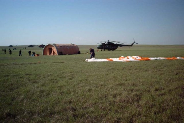 This wide shot reveals the post-landing scene of the Soyuz TM-33 spacecraft not far from the town of Arkalyk, Kazakhstan, soon after the Soyuz 4 ISS Taxi mission ended successfully there. The spacecraft is out of frame but its landing parachute can be seen near center frame. A medical tent, also visible at left, was erected within minutes of the spacecraft's landing, which occurred at 7:52 a.m. Moscow time. Onboard were Yuri Gidzenko, commander; Roberto Vittori, flight engineer; and space flight participant Mark Shuttleworth of South Africa. Gidzenko is with Rosaviakosmos and Vittori represents the European Space Agency (ESA). Photo Credit: NASA/Marty Linde