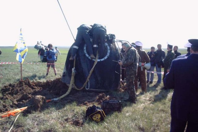 This medium shot reveals the post-landing scene of the Soyuz TM-33 spacecraft not far from the town of Arkalyk, Kazakhstan, soon after the Soyuz 4 ISS Taxi mission ended successfully there. A communication antenna deploys automatically following the landing and technicians prepare to open the hatch while others cordon off the area. Landing occurred at 7:52 a.m. Moscow time. Onboard were Yuri Gidzenko, commander; Roberto Vittori, flight engineer; and space flight participant Mark Shuttleworth of South Africa. Gidzenko is with Rosaviakosmos and Vittori represents the European Space Agency (ESA). Photo Credit: NASA/Marty Linde