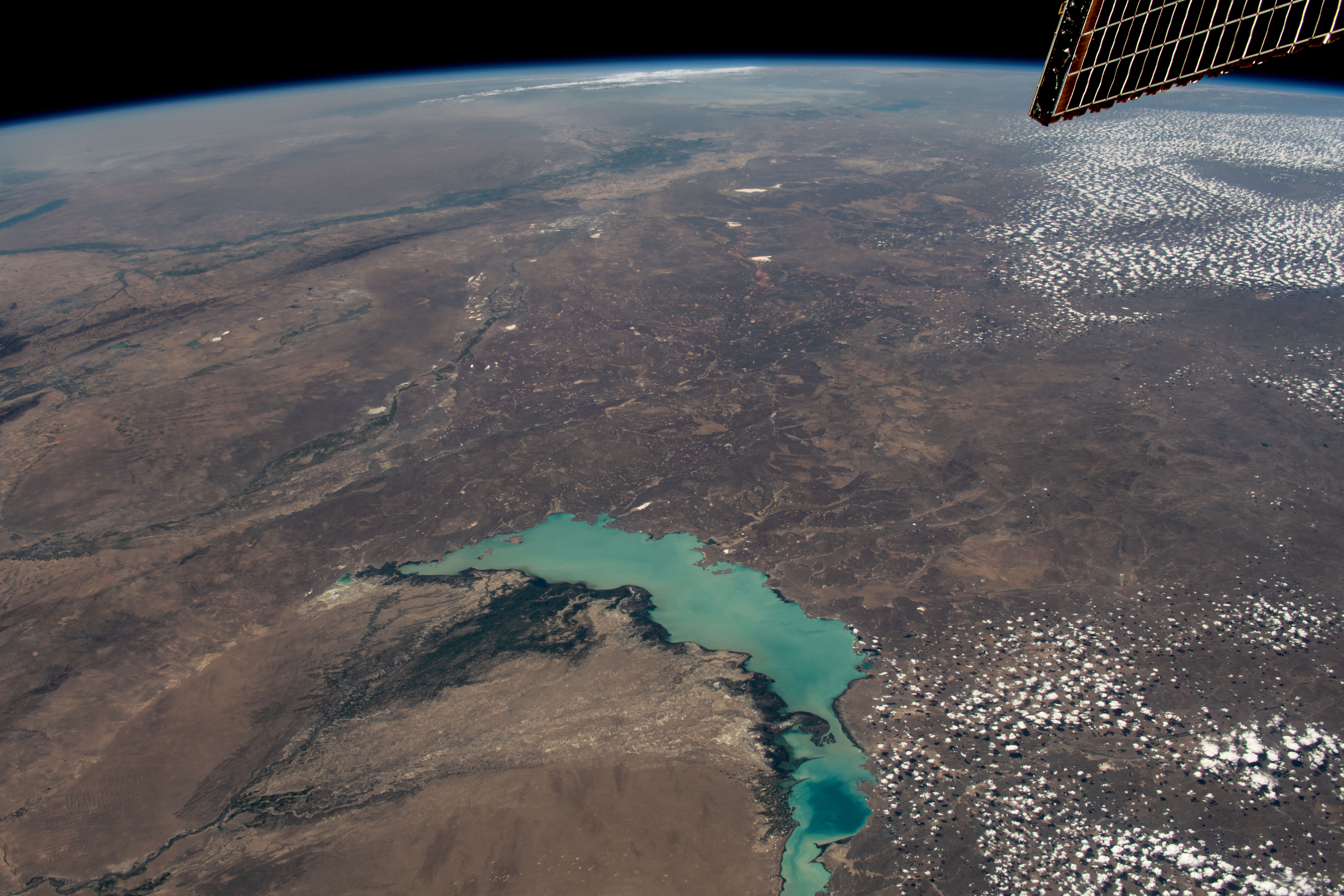 Lake Balkhash, one of the largest in Central Asia, spans roughly 6,500 square miles (17,000 square kilometers) in Kazakhstan. The western part of the lake holds fresh water whereas the eastern side of the basin is salty. The International Space Station soared 261 miles above as this image was taken.