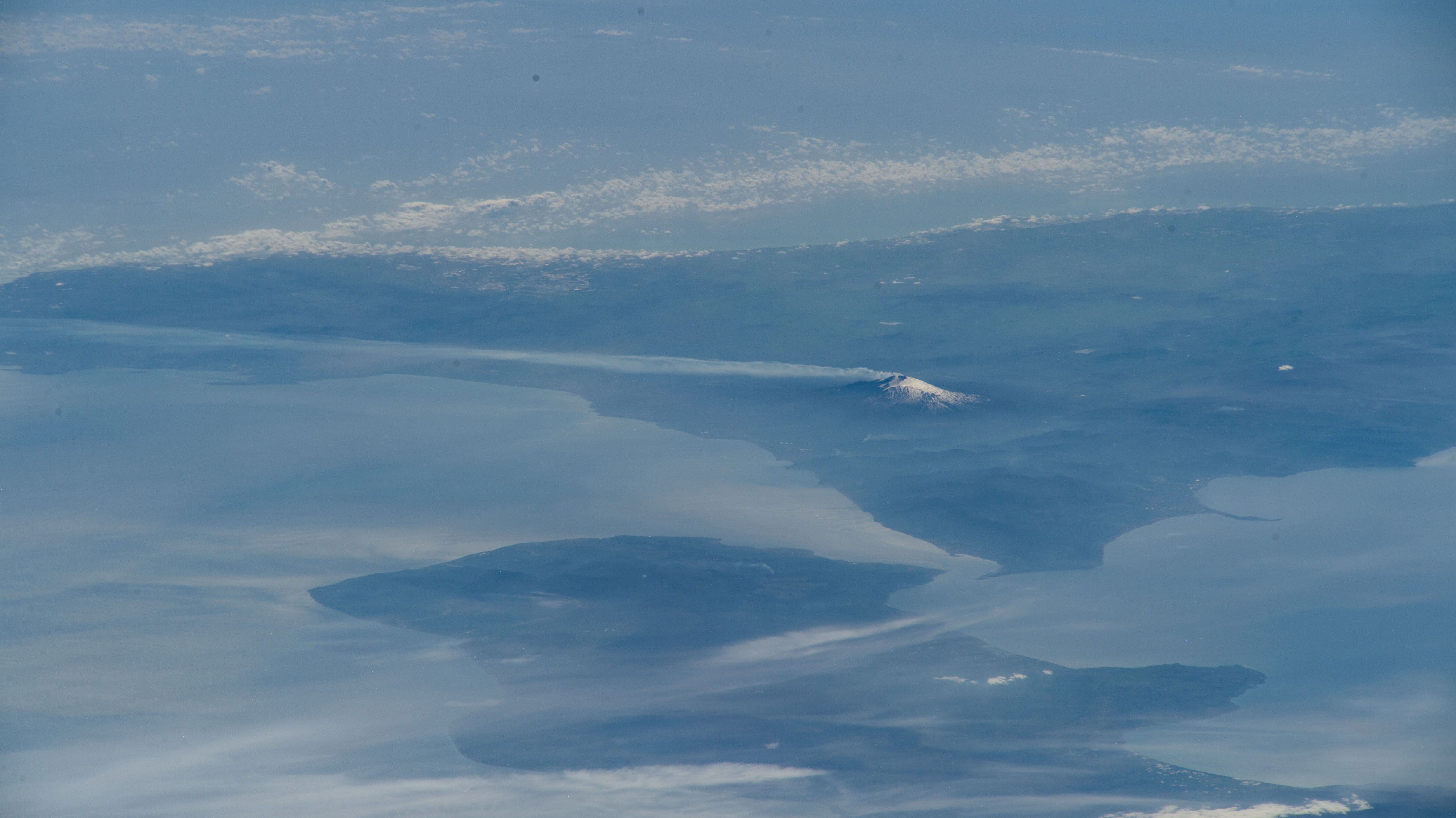 Mount Etna, an active stratovolcano on Italy's island of Sicily, billows smoke in this oblique photograph from the International Space Station as it orbited 262 miles above the Black Sea coast of Ukraine.
