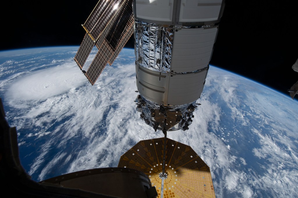 Northrop Grumman's Cygnus space freighter, with one of its cymbal-shaped UltraFlex solar arrays, is pictured attached to the Unity module's Earth-facing port on the International Space Station. The orbital outpost was soaring 261 miles above a storm in the Atlantic Ocean at the time of this photograph.