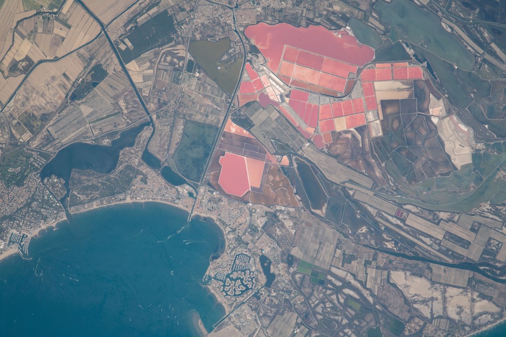 What looks like a collection of fields painted pink is actually a variety of salt lakes in Southern France. Located right off the Mediterranean Sea in the coastal town of Aigues-Mortes, these highly vibrant marshes get their color from pink algae that live within them. The International Space Station was orbiting 265 miles above as this photo was captured.