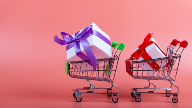 Shopping carts with gift boxes on a pink background