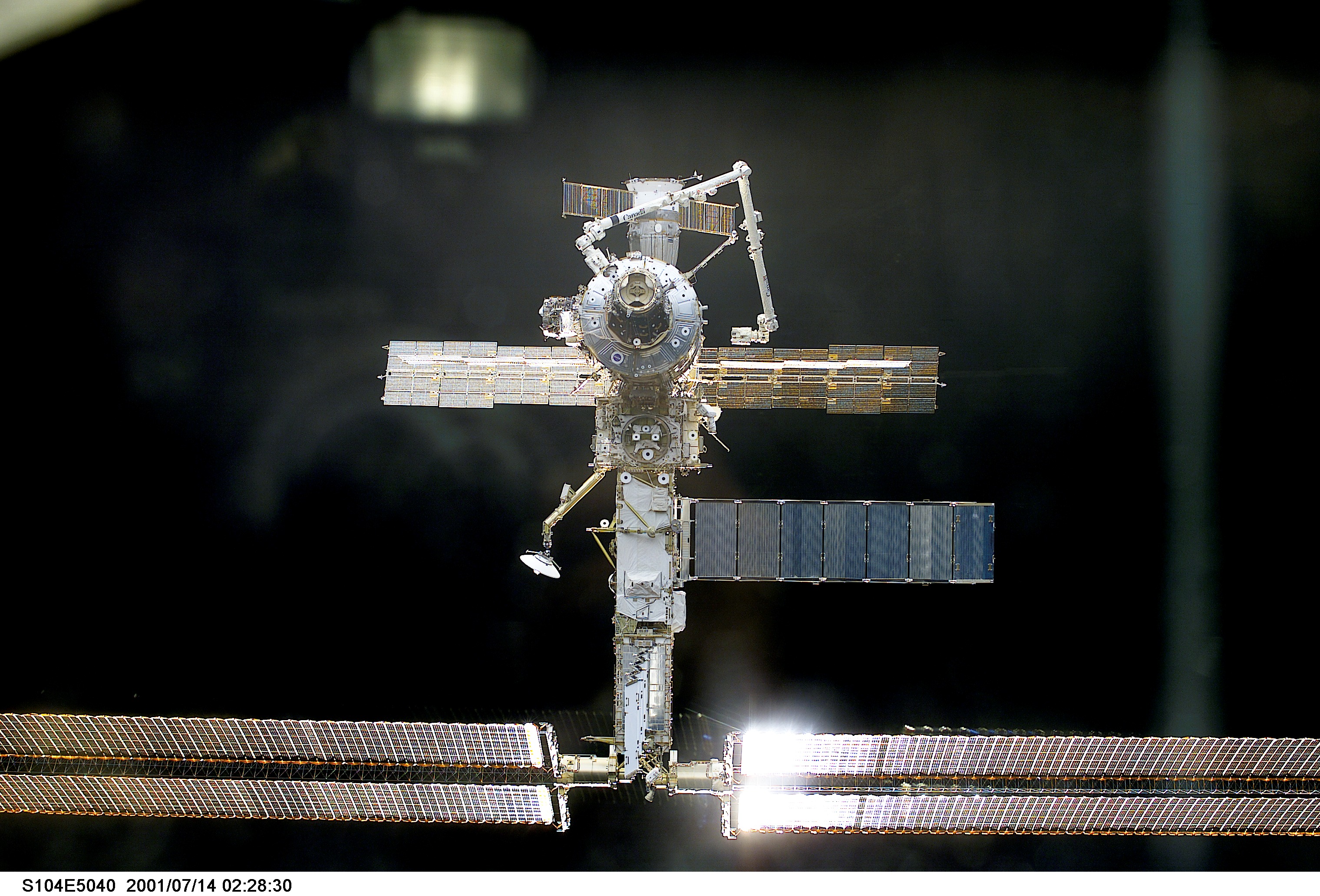 The International Space Station (ISS) almost fills this digital still camera's frame as the Space Shuttle Atlantis closes in for docking.