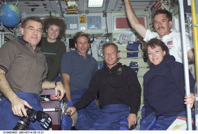 Soon after their ingress into the International Space Station (ISS), STS-104 crewmembers pose for a photograph with Expedition Two crewmembers in the Zvezda Service Module. From left to right are: James S. Voss, Expedition Two flight engineer; Susan J. Helms, Expedition Two flight engineer; Michael L. Gernhardt, STS-104 mission specialist; Steven W. Lindsey, STS-104 mission commander; Janet L. Kavandi, STS-104 mission specialist; and James F. Reilly, STS-104 mission specialist.