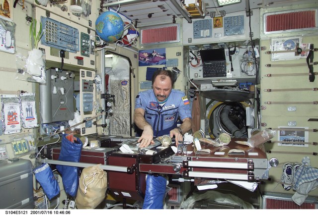 Cosmonaut Yury V. Usachev, Expedition Two commander, organizes different kinds of food in the Zvezda service module aboard the International Space Station (ISS). Representing Rosaviakosmos, Usachev, commander, along with two astronauts, are hosting the STS-104 crew of astronauts on the International Space Station (ISS). The image was recorded with a digital still camera.