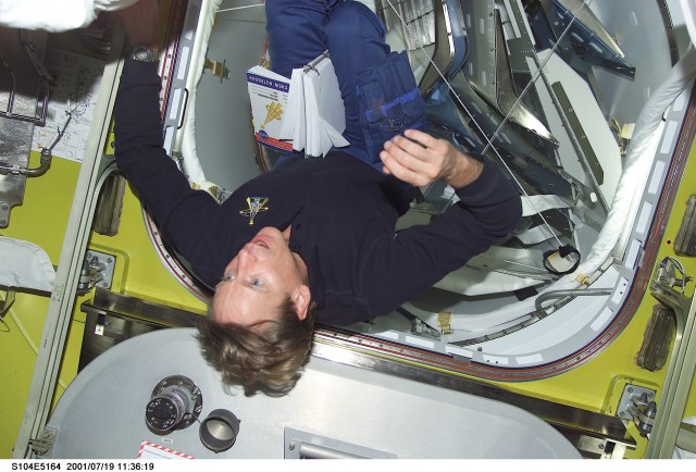 Astronaut Michael L. Gernhardt, STS-104 mission specialist, floats in the Quest Airlock prior to getting suited for the second of three scheduled STS-104 space walks to work on the exterior of the International Space Station (ISS). The image was recorded with a digital still camera.