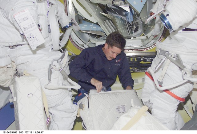 Astronaut James F. Reilly, STS-104 mission specialist, looks over some supplies in the Quest Airlock aboard the International Space Station (ISS). Reilly is one of two assigned space walkers on the STS-104 mission. The third and final scheduled extravehicular activity (EVA) is to utilize the new airlock, marking its first ever usage. The image was recorded with a digital still camera.
