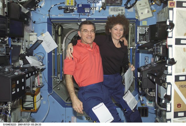 A crew member used a digital still camera to take a picture of members of the Expedition Two crew in the Destiny laboratory. Within the final three weeks of their habitation aboard the International Space Station (ISS), astronauts James S. Voss and Susan J. Helms, flight engineers, both performed important maneuvers with the Canadarm2, Space Station Remote Manipulator System (SSRMS), during the STS-104 mission. Cosmonaut Yury V. Usachev, Expedition Two commander, is out of frame.