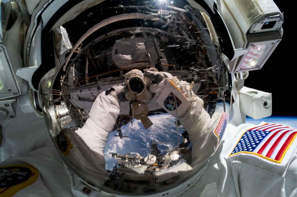 NASA astronaut and Expedition 68 Flight Engineer Woody Hoburg points the camera toward himself and takes an out-of-this-world "space-selfie" during a six-hour and three-minute spacewalk to install a roll-out solar array on the International Space Station's truss structure.