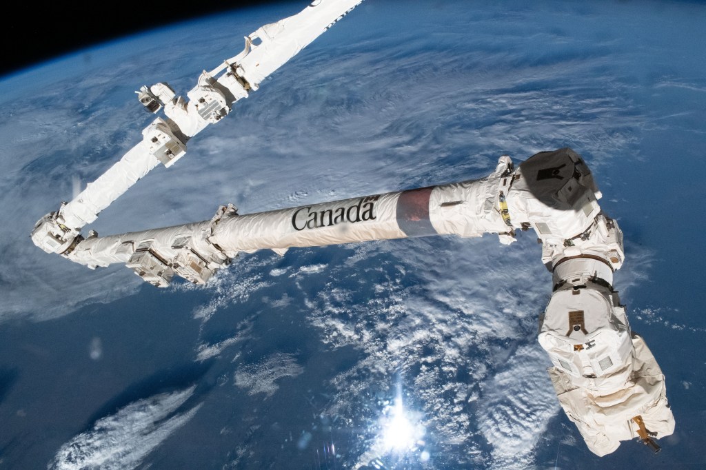 The Canadian Space Agency's major contribution to the International Space Station, the 57.7-foot-long Canadarm2 robotic arm, which can maneuver spacecraft, science payloads, and spacewalking astronauts, is pictured as the orbital lab soared 259 miles above a cloudy Texas.