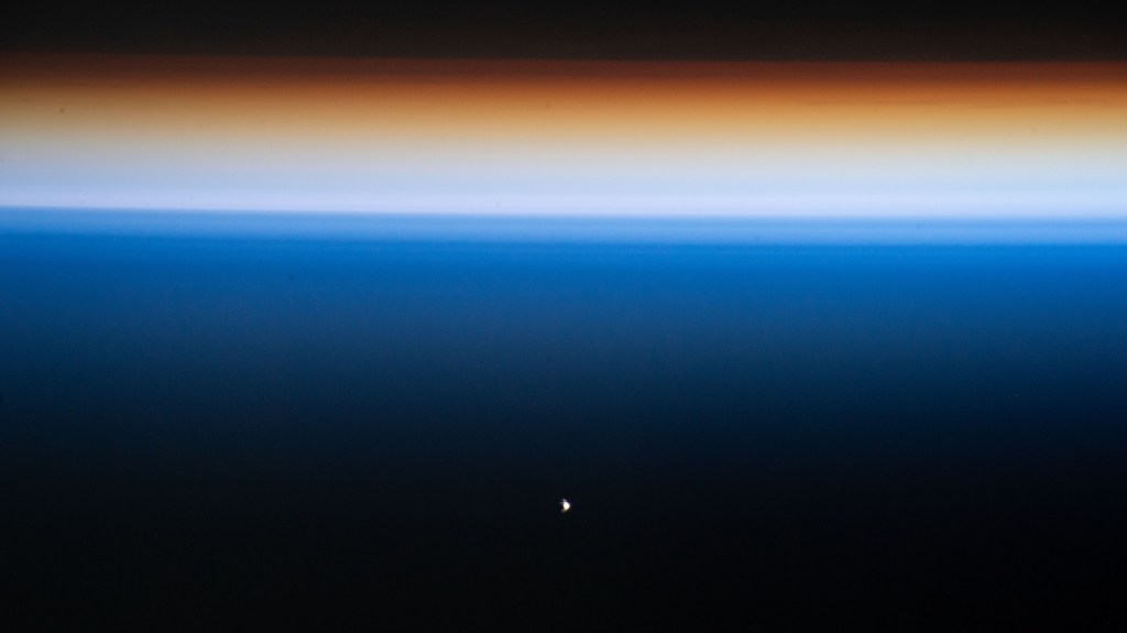 The SpaceX Dragon Endeavour crew ship (white dot at lower center) carrying four Axiom Mission 1 astronauts approaches the International Space Station during an orbital sunset less than a day after launching from NASA's Kennedy Space Center in Florida. Both spacecraft were orbiting 261 miles above the Philippine Sea near the U.S. island territory of Guam.
