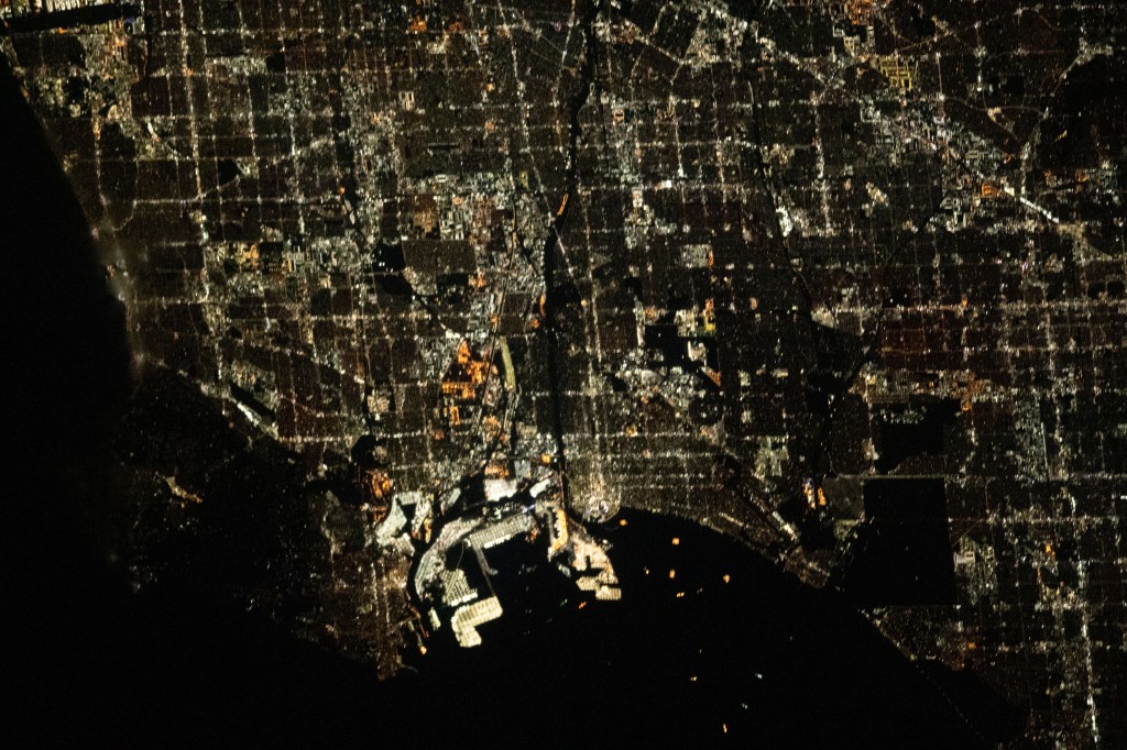The city lights of Los Angeles, California, and its surrounding suburbs, are pictured from the International Space Station as it orbited 261 miles above. Terminal Island, an artificial island containing the ports of Los Angeles and Long Beach, is featured prominently at the bottom center of this photograph.