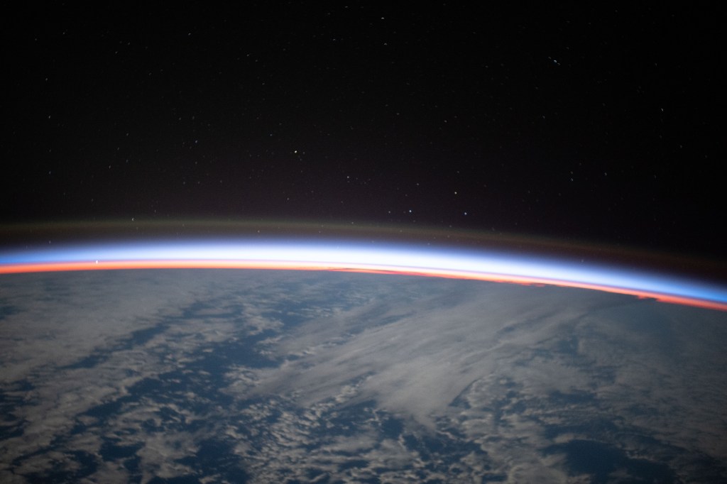 The first rays of an orbital sunrise begin illuminating Earth's atmosphere in this photograph from the International Space Station as it orbited 267 miles above the southern Pacific Ocean.