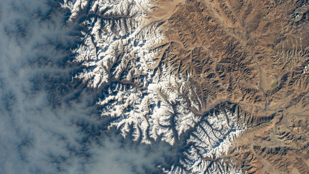 Clouds gather on Nepal's sub-tropical side of the Himalayas with Mount Everest at the center of this photograph taken by an external high definition camera on the International Space Station as it orbited 263 miles above the Indian subcontinent.