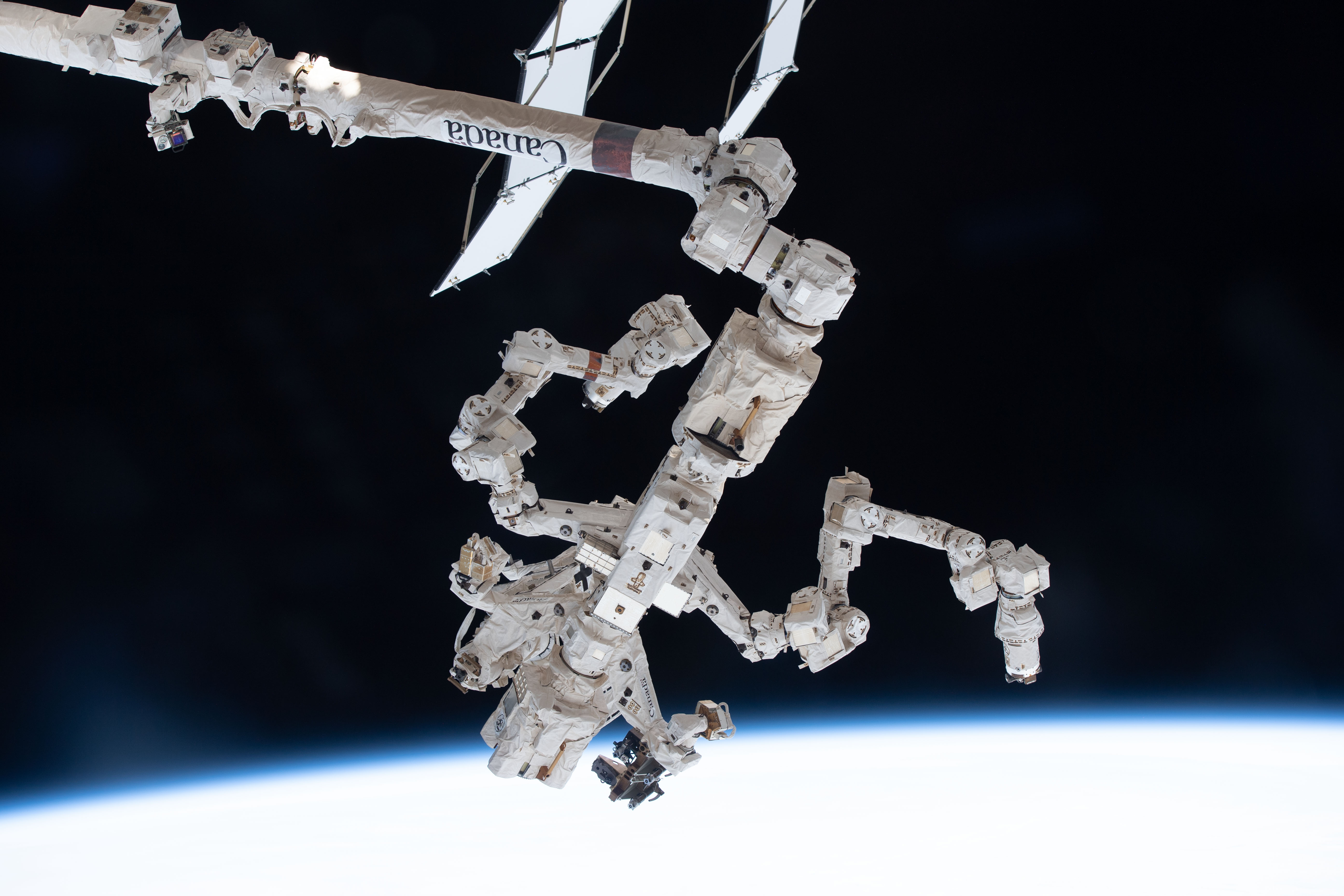 The Special Purpose Dexterous Manipulator (SPDM), also known as Dextre, is pictured attached to the International Space Station's Canadarm2 robotic arm. The SPDM is the orbiting lab's fine-tuned robotic hand designed for precise handling abilities and routine maintenance tasks such as replacing batteries and cameras in the harsh environment of space.